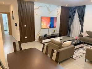 Familie appartement | Woonruimte | Een 65-inch smart-tv met satellietzenders