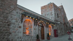 En byggnad i sten med en skylt som visar texten ”Kani Divan Hotel” och en traditionell, välvd entré.