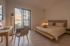 A modern bedroom with a bed, a desk, and a chair.