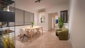Ein modernes Interieur mit Essbereich, einem grünen Sessel und einer Pflanze.
