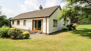 Einbungalow mit geneigtem Dach, Schornstein und einer großen Schiebetür.