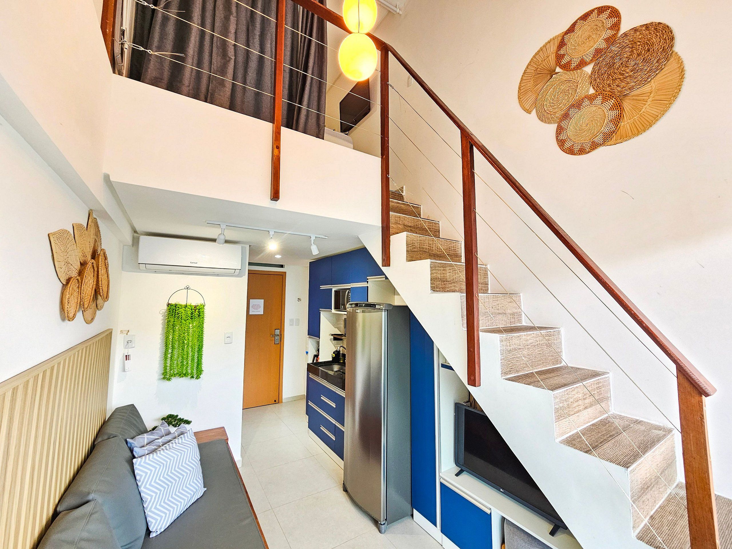 A modern apartment with a staircase, a kitchen, and a living area.