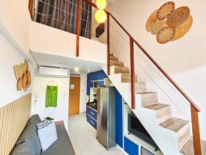Een modern appartement met een trap, keuken en een zithoek.
