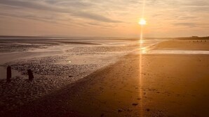 A beach with a sunset, calm waters, and a distant shoreline. - Bubbles & Bliss - Hot Tub/Garden | Pass the Keys (Rye)