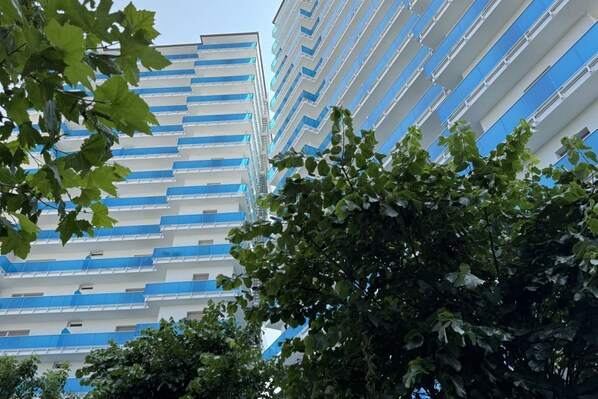 A multi-story building with a modern architectural design, featuring a series of balconies and windows.