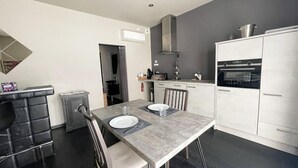 A modern kitchen with white cabinets, a built-in oven, and a grey countertop. - A charming gite (Sainte-Luce-sur-Loire)