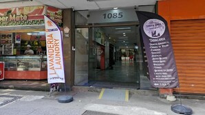 Una fachada con un letrero que dice 'Lavanderia Laundry' y un cartel publicitario que anuncia 'Tobacco & Cigarettes'.