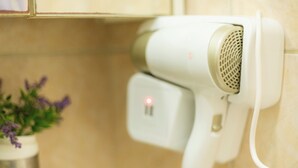 Un secador de pelo montado en la pared, con panel de control y cable de alimentación.