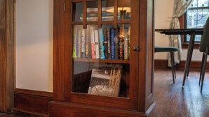 Ein Holzregal mit Glastüren, das verschiedene Bücher und ein Magazin mit dem Titel "Campay" enthält.