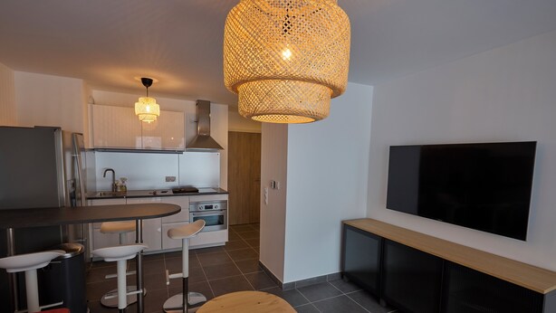 Eine moderne Küche mit Essbereich, Fernseher und Kamin.