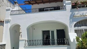 A two-story building with a balcony and a covered entrance.