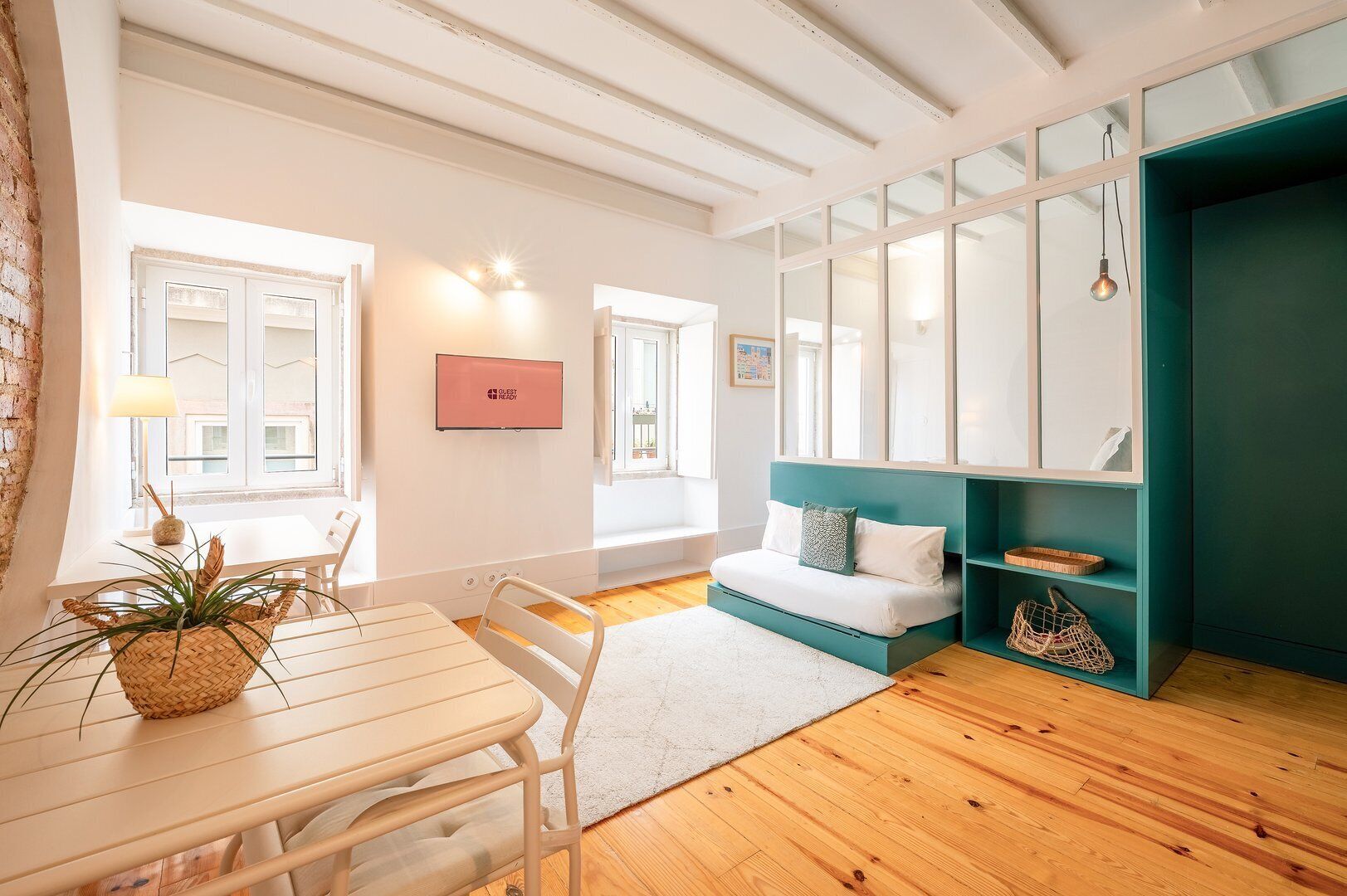 Een moderne kamer met een bed, bureau en raam.