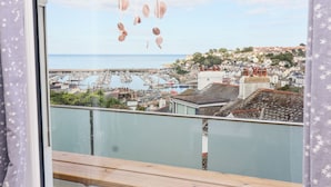 Un balcón con vista a un puerto deportivo y una ciudad.