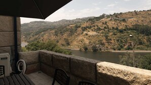 Ein Balkon mit Blick auf einen Fluss und Hügel.
