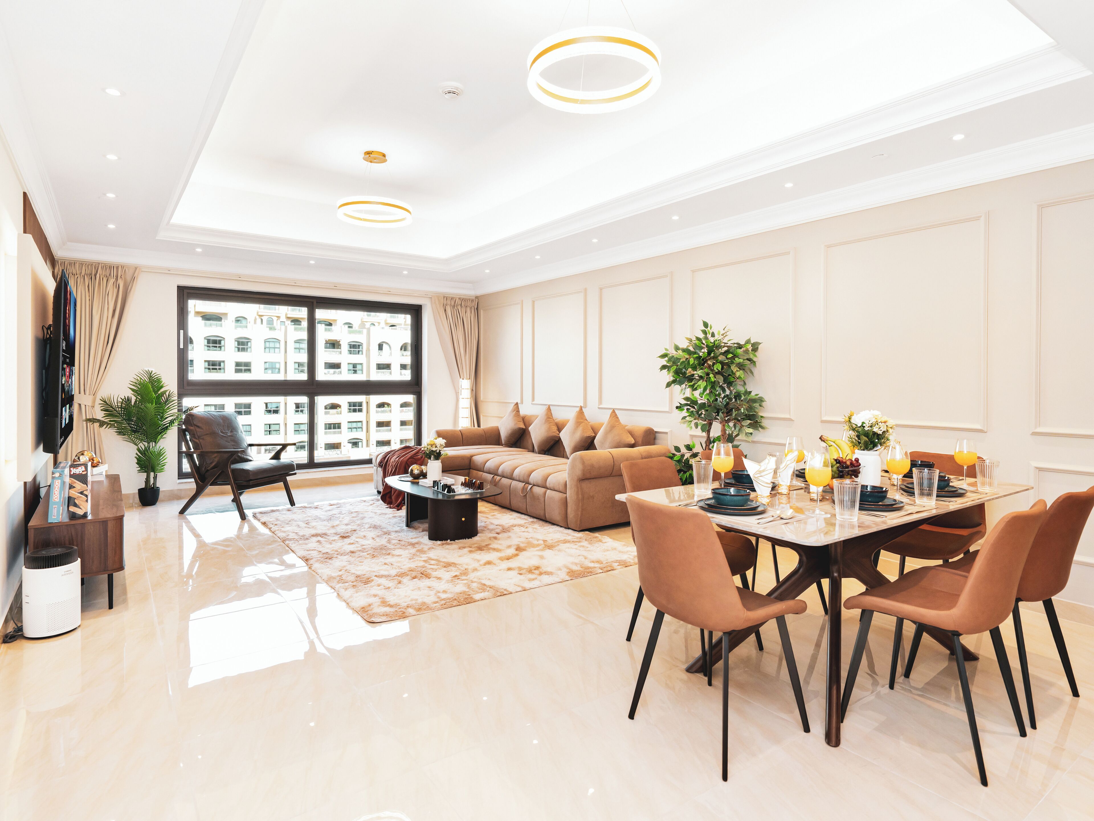 Una sala de estar moderna con sofá, mesa de centro y zona de comedor con sillas.