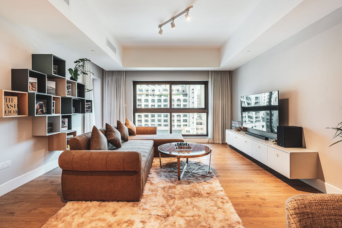 Een moderne woonkamer met een bank, salontafel en een boekenkast.