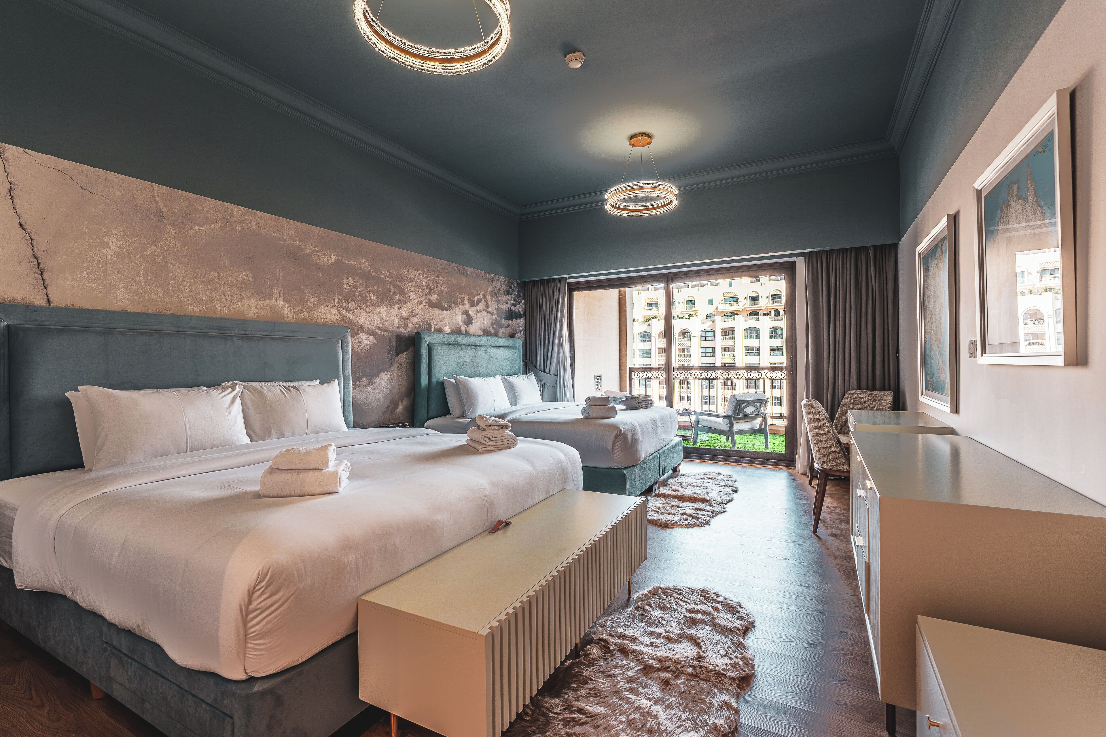 Une chambre d’hôtel moderne avec deux lits, une grande fenêtre et une vue sur la ville.