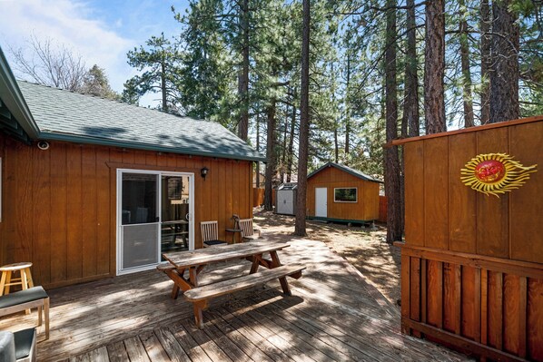 A wooden cabin with a picnic table and a covered seating area. - G&P Moonridge (Big Bear Lake)