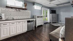 A modern kitchen with white cabinetry, a built-in oven, and a large island.