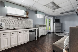 A modern kitchen with white cabinetry, a built-in oven, and a large island.
