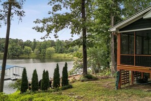 A lakeside cabin with a deck overlooking the water, surrounded by trees and greenery. - Smith Lake Serenity (Jasper)