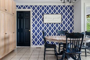 A dining area with a black door, a patterned wall, and a framed sign that reads 'be our guest'. - Smith Lake Serenity (Jasper)