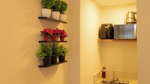 Une cuisine avec des étagères où sont disposées des plantes et une machine à café.