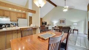 Una cocina con armarios de madera, una mesa de comedor y un ventilador de techo.