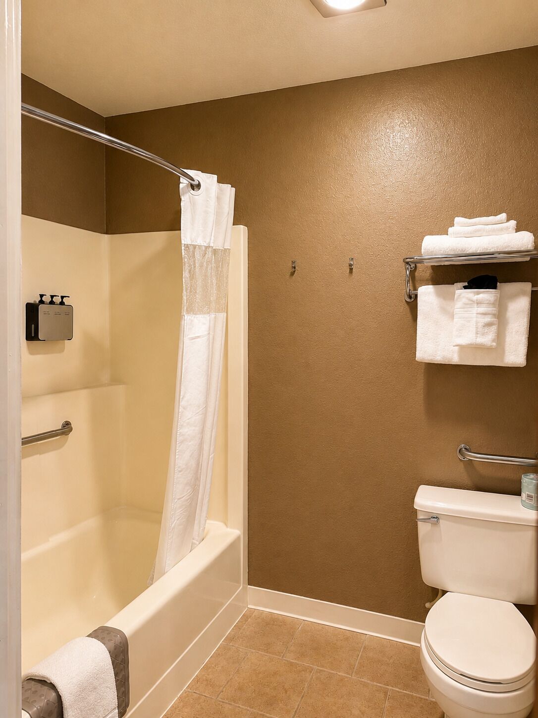 A bathroom with a bathtub, toilet, and a towel rack.