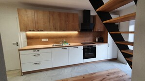 Una cocina moderna con armarios de madera, un lavamanos y una estufa.