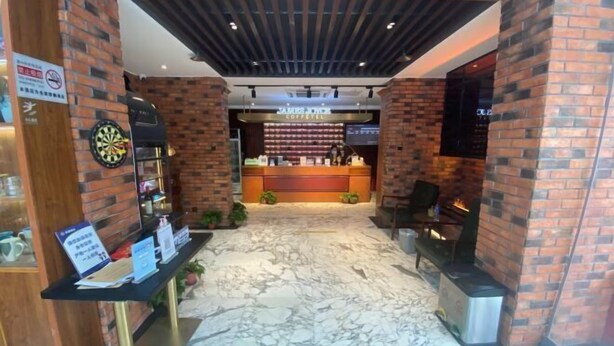 A modern interior with a dartboard, a coffee bar, and a fireplace. - James Joyce Coffetel Hotel (Beijing Xizhimen Xinjiekou Subway) (Beijing)