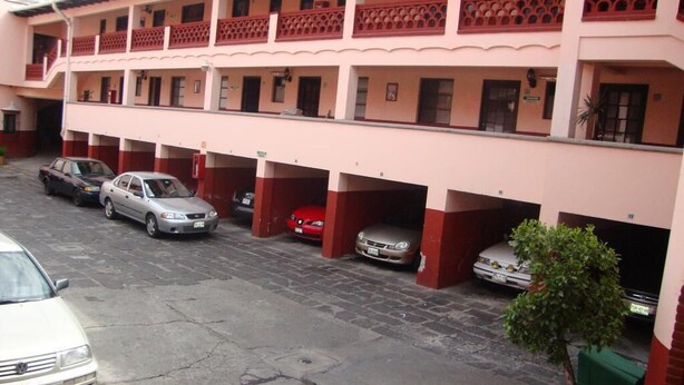 A multi-story parking garage with several cars parked. - Hotel Virreyes (Puebla)