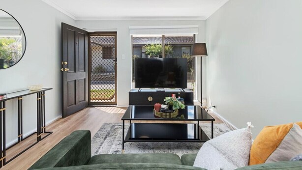A modern living room with a flat-screen TV, a coffee table, and a sofa. - Coastal Elegance! A Luxurious, Dreamy Escape! (Scarborough)