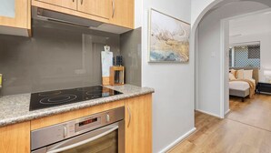 A modern kitchen with wooden cabinets, a built-in oven, and a granite countertop. - Coastal Elegance! A Luxurious, Dreamy Escape! (Scarborough)
