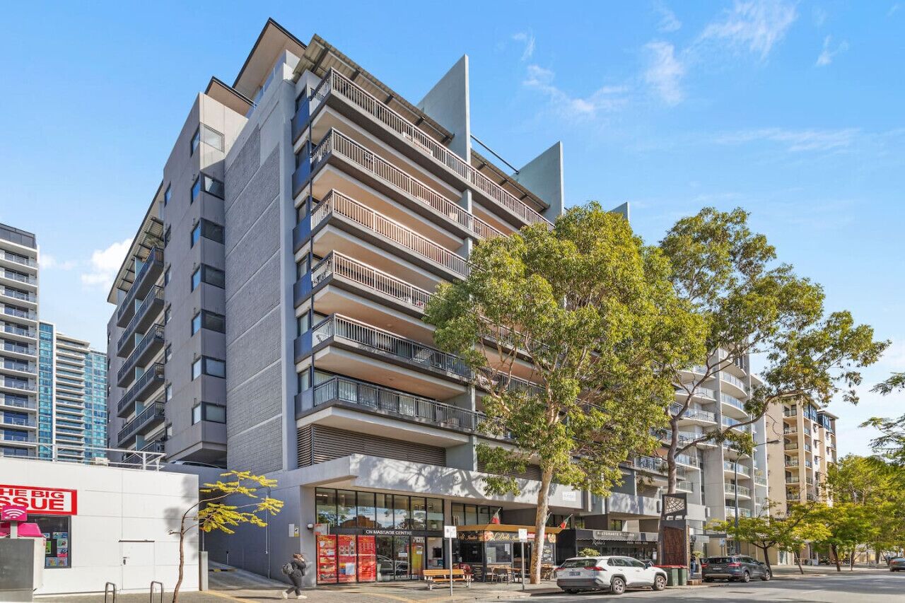 A modern multi-story building with balconies, a massage center, and a visible storefront.