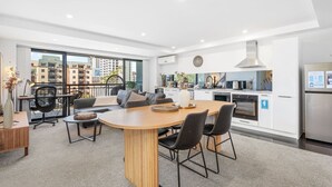 Um apartamento moderno com área de jantar, cozinha e janelas amplas com vista para a cidade.
