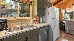 Una cocina con un lavamanos doble, electrodomésticos de acero inoxidable y armarios de madera.