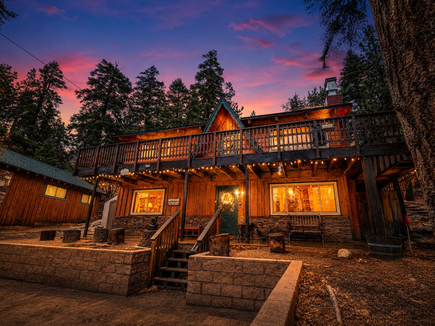 Une cabane en bois avec un balcon, des marches en pierre et une enseigne indiquant la présence d’un restaurant.