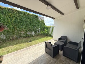 A covered patio area with a seating arrangement and a wall covered in greenery. - Beautiful house in the most exclusive área of San Miguel (San Miguel)