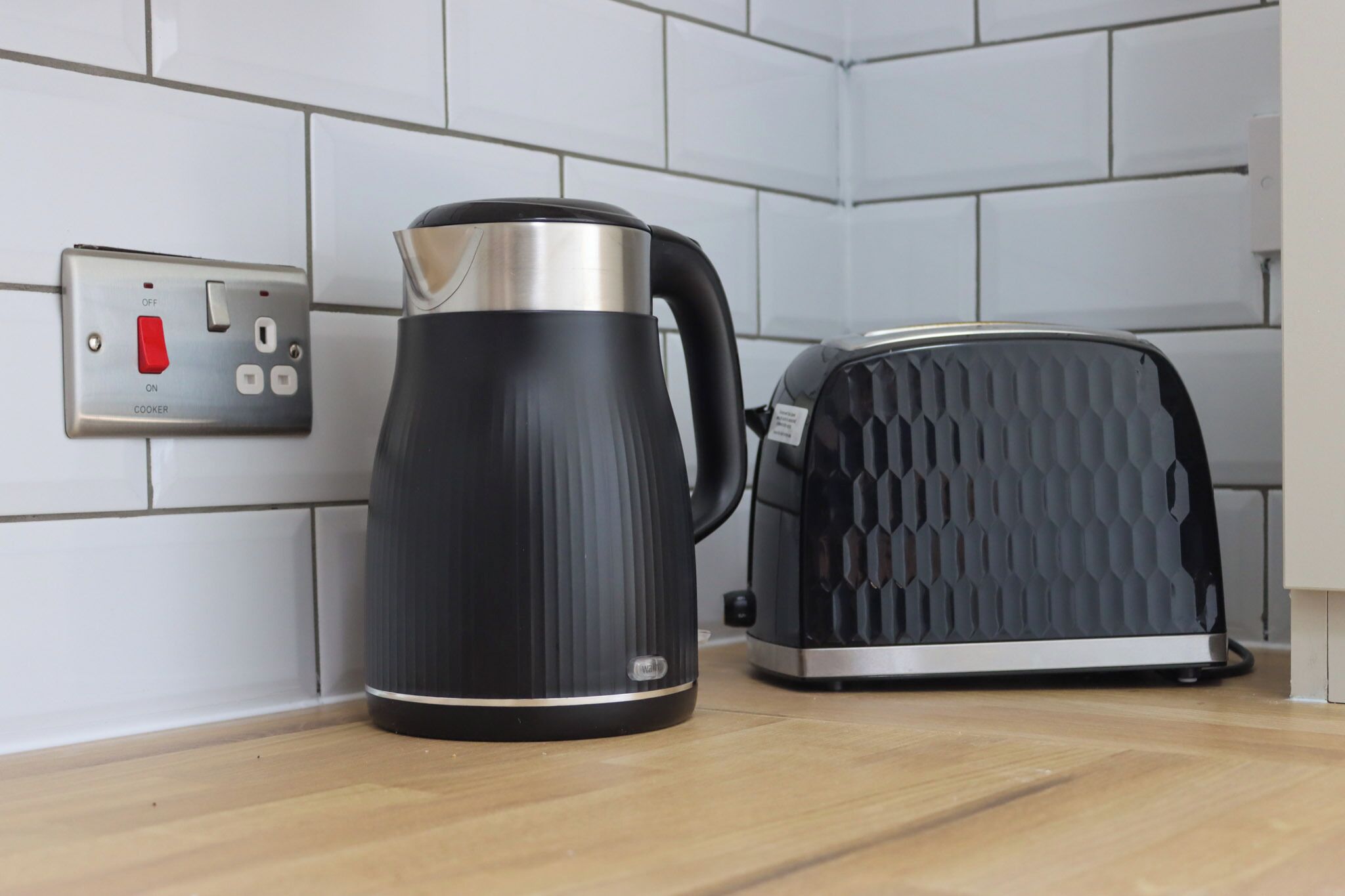 A kitchen with a kettle and toaster on the counter.