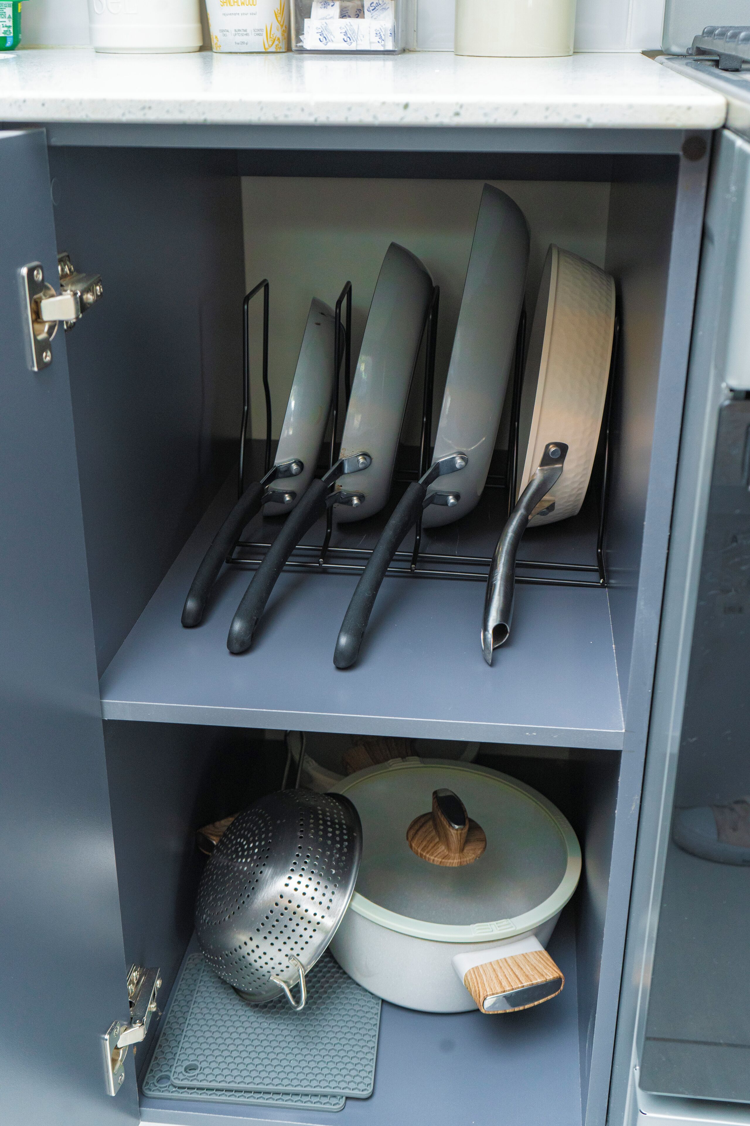 Un armario de cocina con utensilios y batería de cocina.