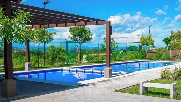A swimming pool with a pergola, surrounded by greenery and a clear sky. - Beautiful 3-bedroom house in the most exclusive zone of  Sn Miguel with WiFi, AC (San Miguel)