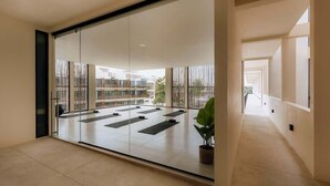 Un'ampia stanza con un'ampia porta finestra che si apre su una zona esterna con tappetini per esercizi.