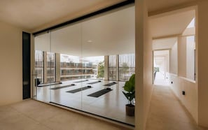 A spacious room with a large sliding glass door leading to an outdoor area with exercise mats.