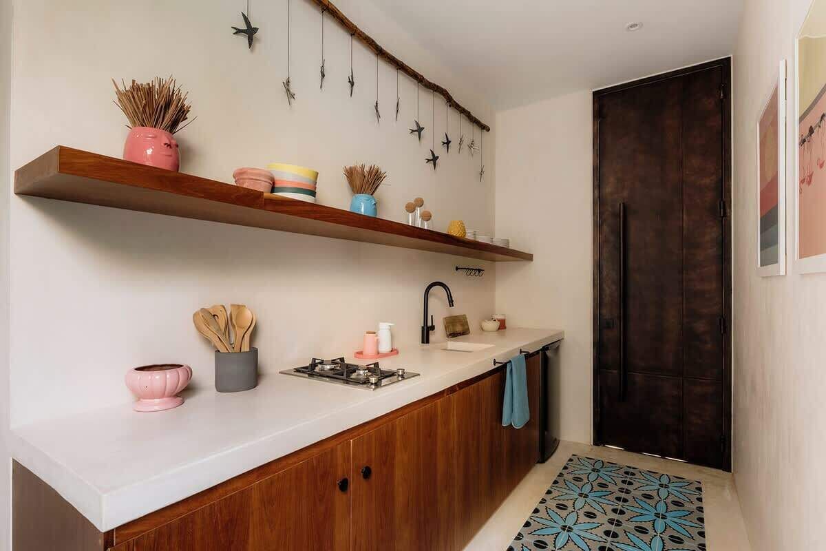 Una cocina moderna con armarios de madera, encimera blanca y una decoración con una rama colgante.