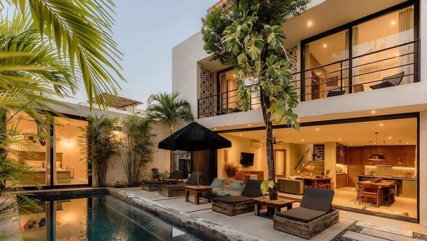 A modern two-story house with a swimming pool, outdoor seating, and a visible kitchen. - Casa Chacalaca Perfect Bachelorette Villa (Tulum)