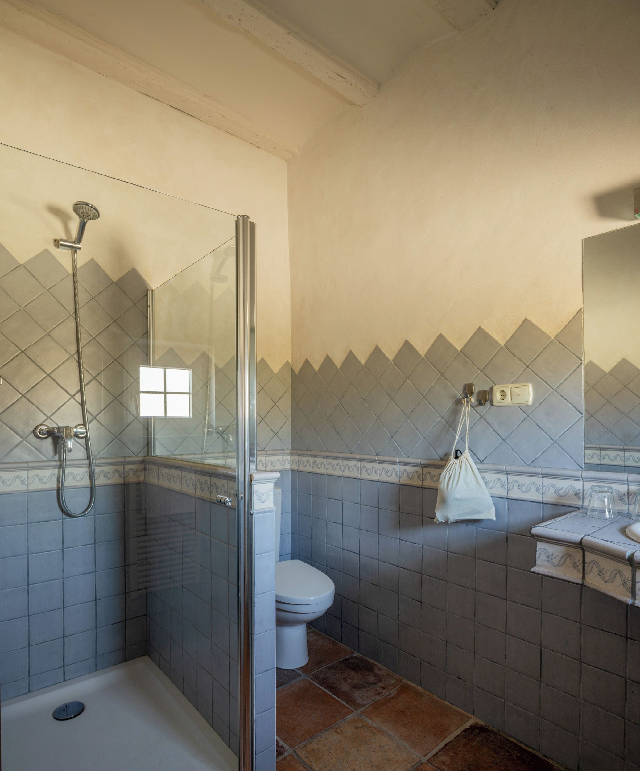 A bathroom with a shower, toilet, and sink.