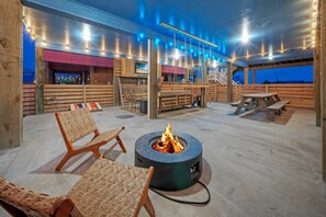 An outdoor seating area with a fire pit, wooden benches, and chairs. - Salty Texan by Avantstay Central Location, Views (Port Aransas)