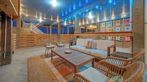 A cozy, well-lit wooden interior with a sofa, chairs, and a staircase. - Salty Texan by Avantstay Central Location, Views (Port Aransas)
