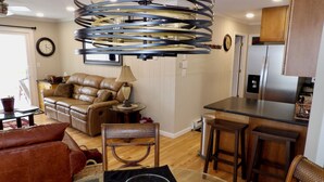 A modern kitchen with a stainless steel refrigerator, a dining area with a glass table, and a leather sofa. - Tranquility Beech: 2BR Condo Steps from the Resort--Parking Lot Level: No Stairs (Banner Elk)